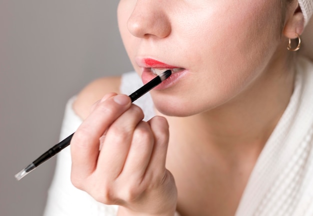 Close-up female applying lipstick