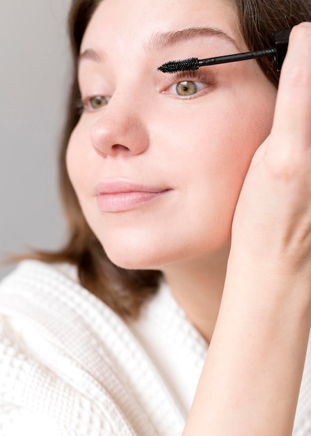 Free photo close-up female applying mascara