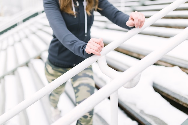 Foto gratuita primo piano dell'atleta femminile che si esercita sulla scala nell'inverno