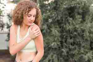 Free photo close-up of female athlete having pain in shoulder