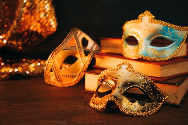 Крупный план женской карнавальной маски с книгами на деревянный стол