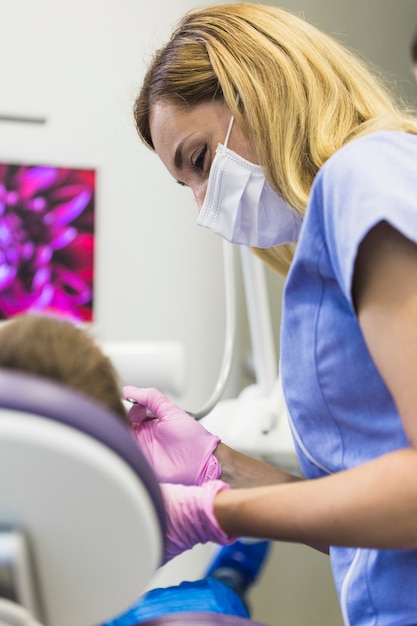 患者の歯を調べている女性医師のクローズアップ