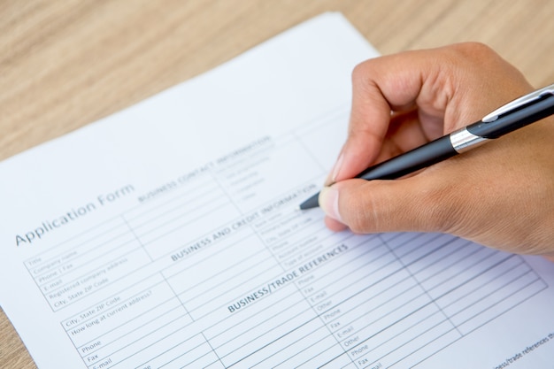 Close-up of female hand filling application form