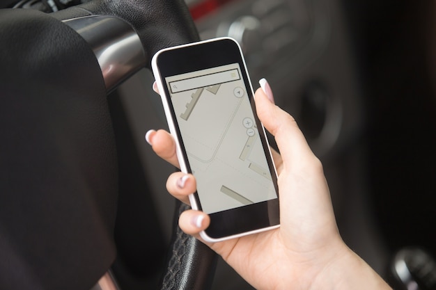 Close-up of female hand holding phone with navigation map