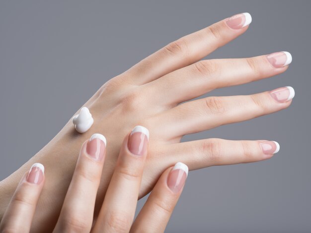 Close-up female hands apllying hand cream