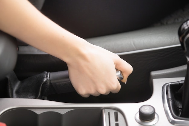 Close-up of female hands holding a handbrake