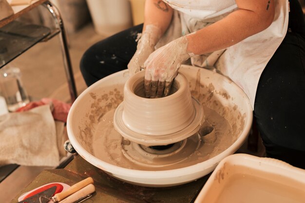Close-up of female hands making pottery on a wheel