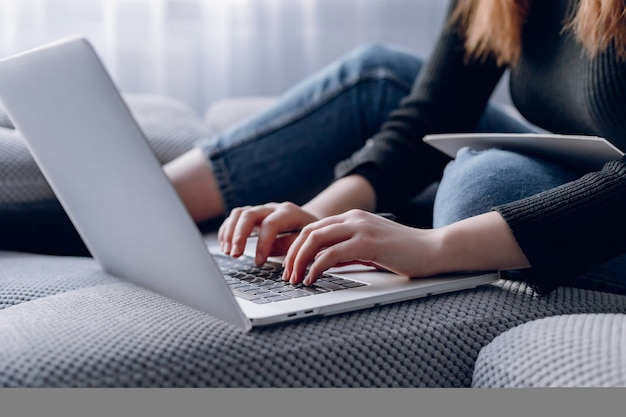 Free photo close-up of female hands typing on stylish laptop in modern interior. work online and laptop.