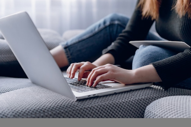 현대적인 인테리어에 세련 된 노트북에 입력하는 여성 손 클로즈업. 온라인 및 노트북 작업.
