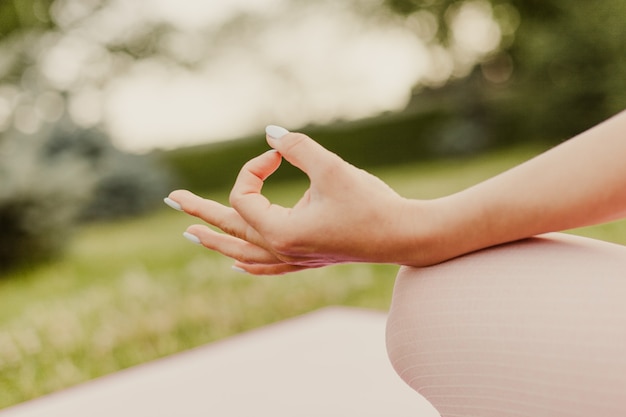 Close-up of female index finger and thumb in symbol of meditation, concept of inner harmony and mental health.