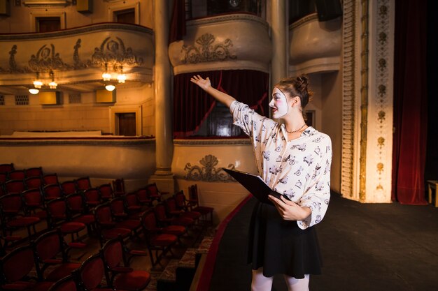 Close-up of female mime holding script rehearsing on stage