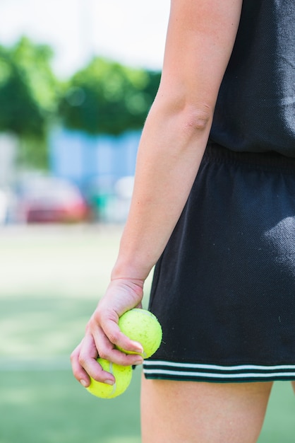 テニスボールを保持している女性プレーヤーのクローズアップ