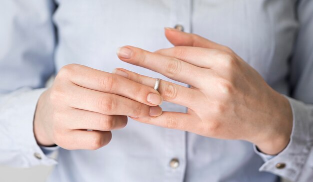 Close-up female pulling off marriage ring