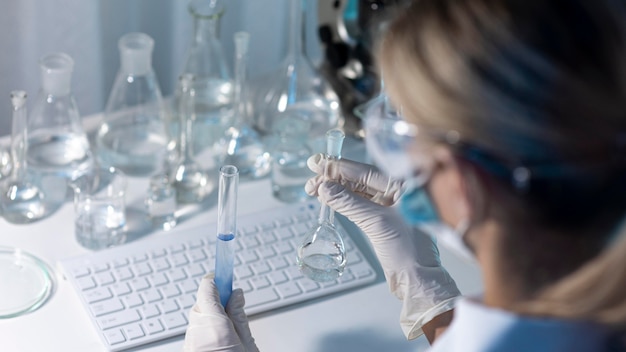 Close-up female researcher holding glassware