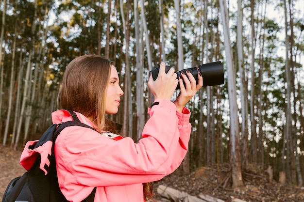 숲에서 촬영하는 여성 여행자의 근접 촬영