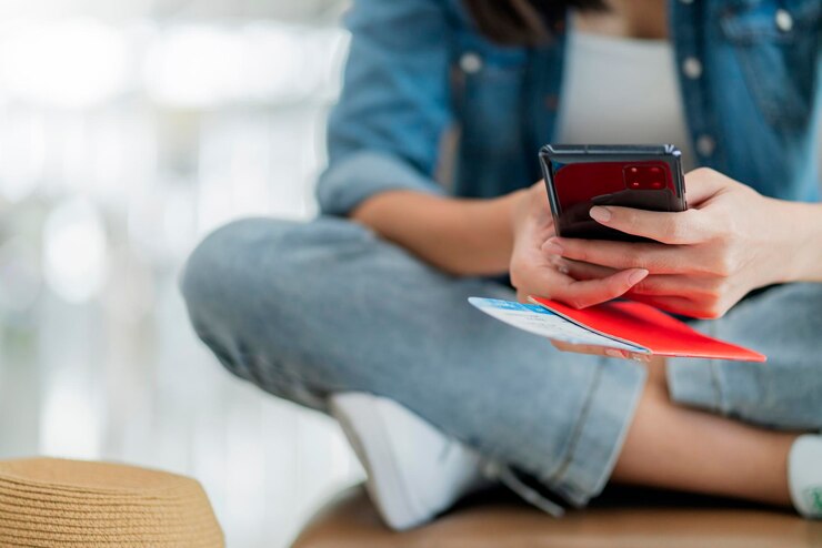 Free Photo close up female traveller hand hold passport using smartphone for checking online for boarding departure at airport terminalasian female sit relax at wating area wwating for boarding travel concept