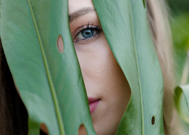 Close-up female watching through leaves