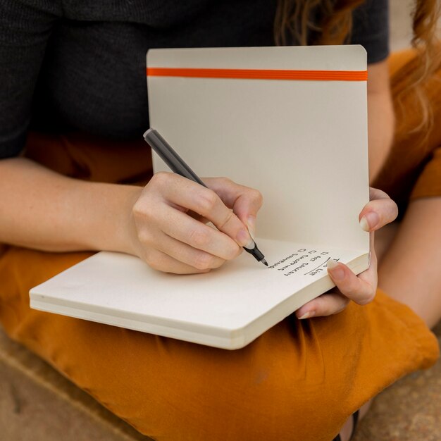 close-up female writing in journal