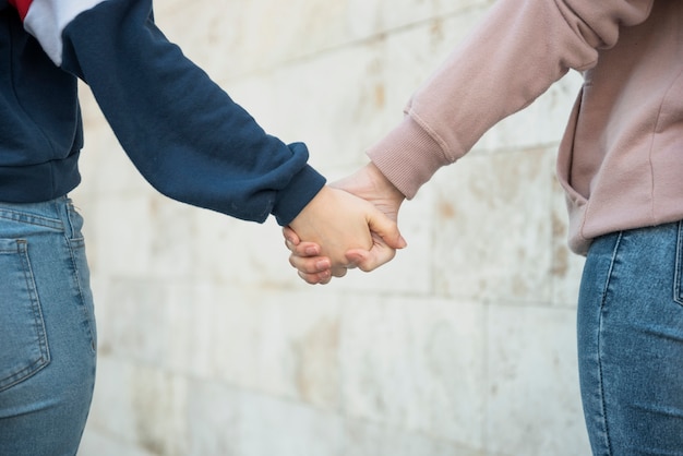 Free photo close-up females walking while holding hands