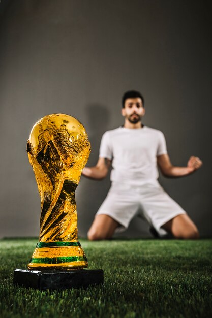 Close-up FIFA trophy near athlete