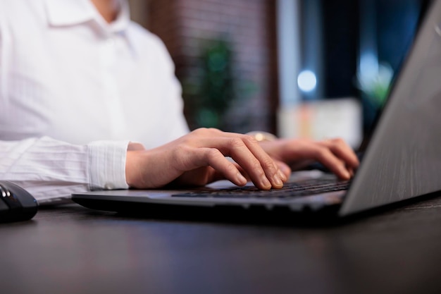 Close up of financial advisor sitting at desk in office workspace while developing marketing strategy on computer. Businesswoman analyzing accounting data and project state.