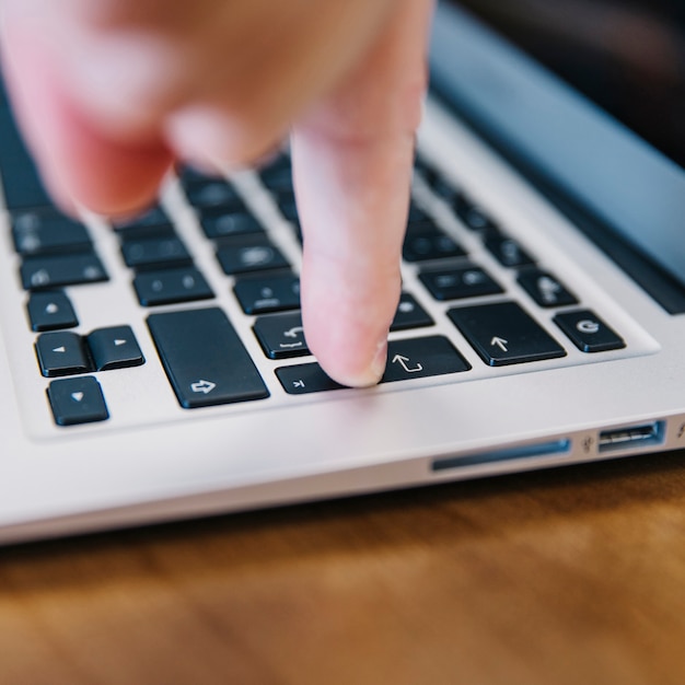 Close-up of finger pressing keyboard button