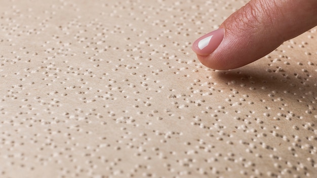Close-up finger touching braille page