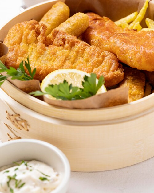 Close-up of fish and chips in bowl with lemon