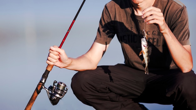 Free photo close-up of a fisherman with fresh catch and fishing rod