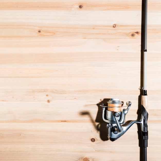 Close-up of fishing rod on wooden desk