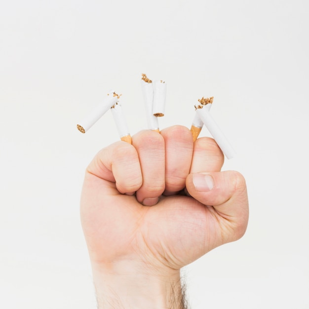 Free photo close-up of fist creasing the cigarette butts isolated on white background