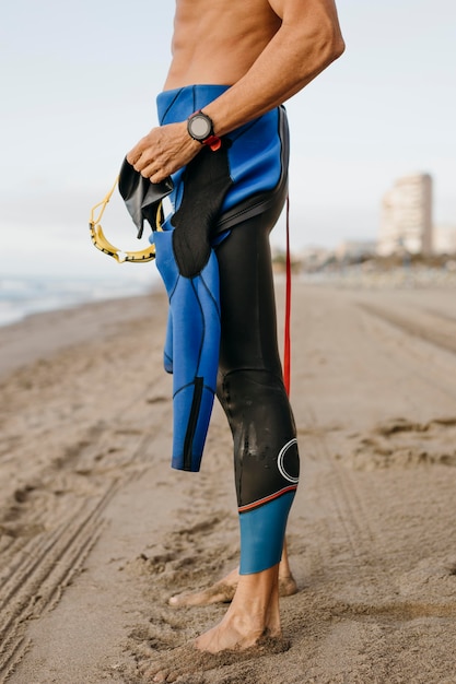 Close-up fit swimmer standing on beach