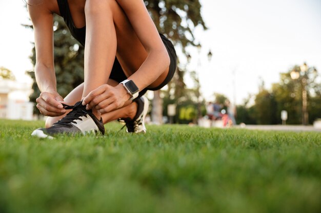 Close up of fitness woman tying her shoelaces