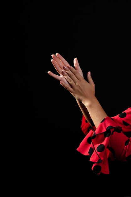 Free photo close-up flamenca clapping hands on black background