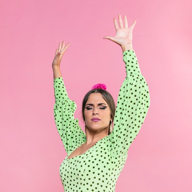 Макро танцор фламенко, поднимая руки на розовом фоне
