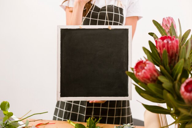 Free photo close-up florist holding a black board