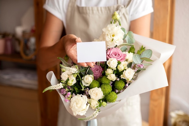 Close up florist holding bouquet and note