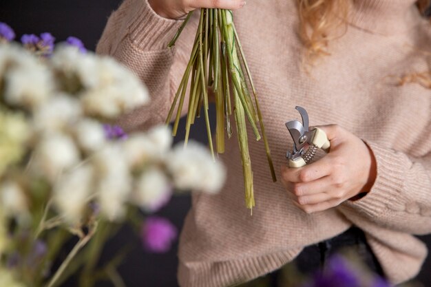 Close up florist holding cutting tool