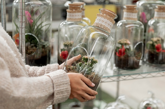 Close-up florist holding transparent jar