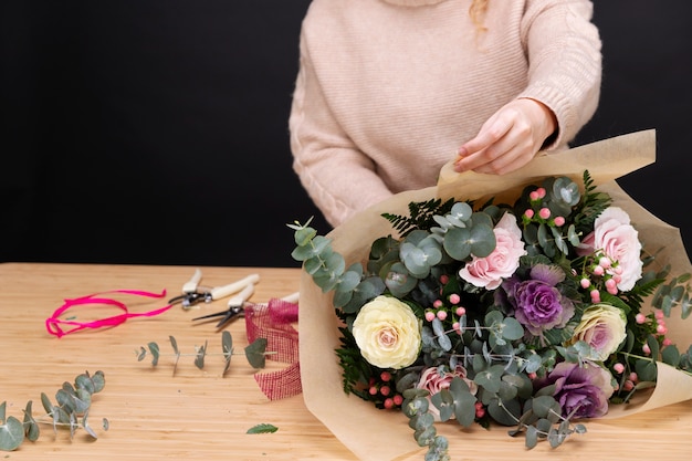 Free photo close up florist making bouquet