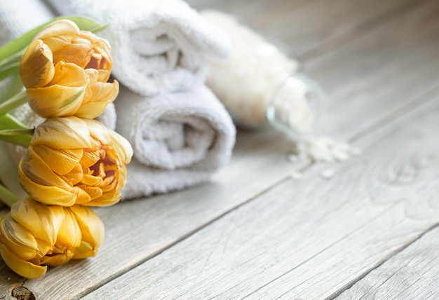 Close up of flowers with bath accessories on a blurred background. Health and beauty concept.