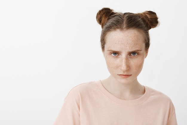 Free photo close-up of focused teenage girl posing against the white wall