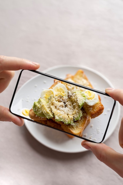 食事の写真を撮る食品愛好家のクローズアップ