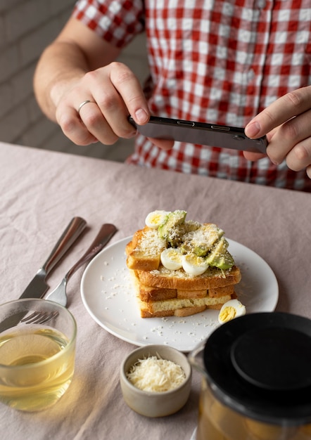 食事の写真を撮る食品愛好家のクローズアップ