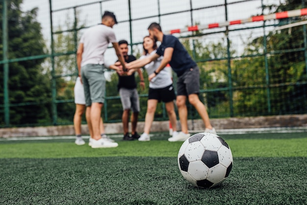 緑のフィールドでサッカーボールのクローズアップ..一緒にプレーするプレーヤー..