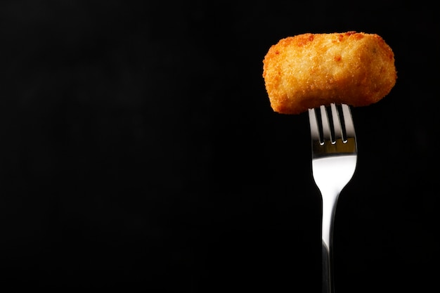 Close up fork holding food croquette