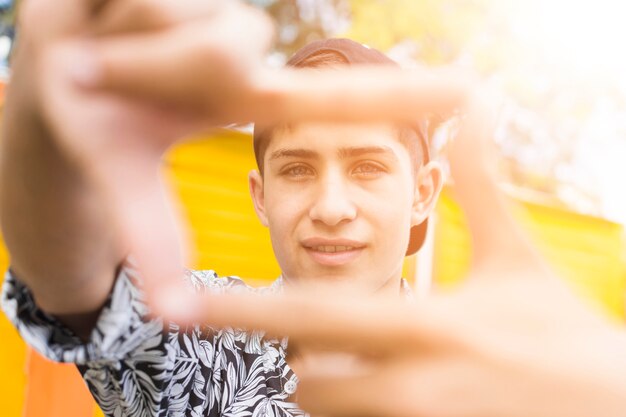 Close-up of frame made from smiling boy's fingers