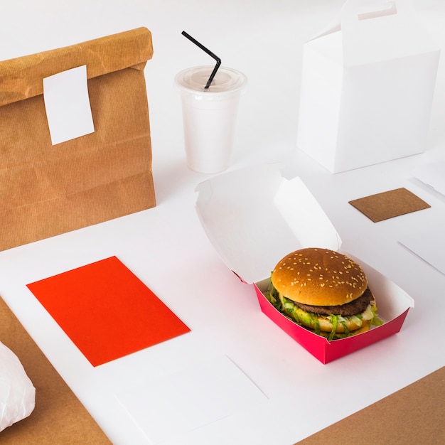 Close-up of fresh burger with disposal cup and food parcel