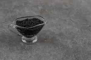 Free photo close up of fresh caviar in glass bowl over grey surface