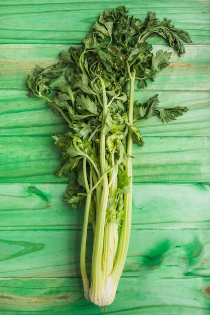 Foto gratuita primo piano di sedano fresco su fondo di legno verde